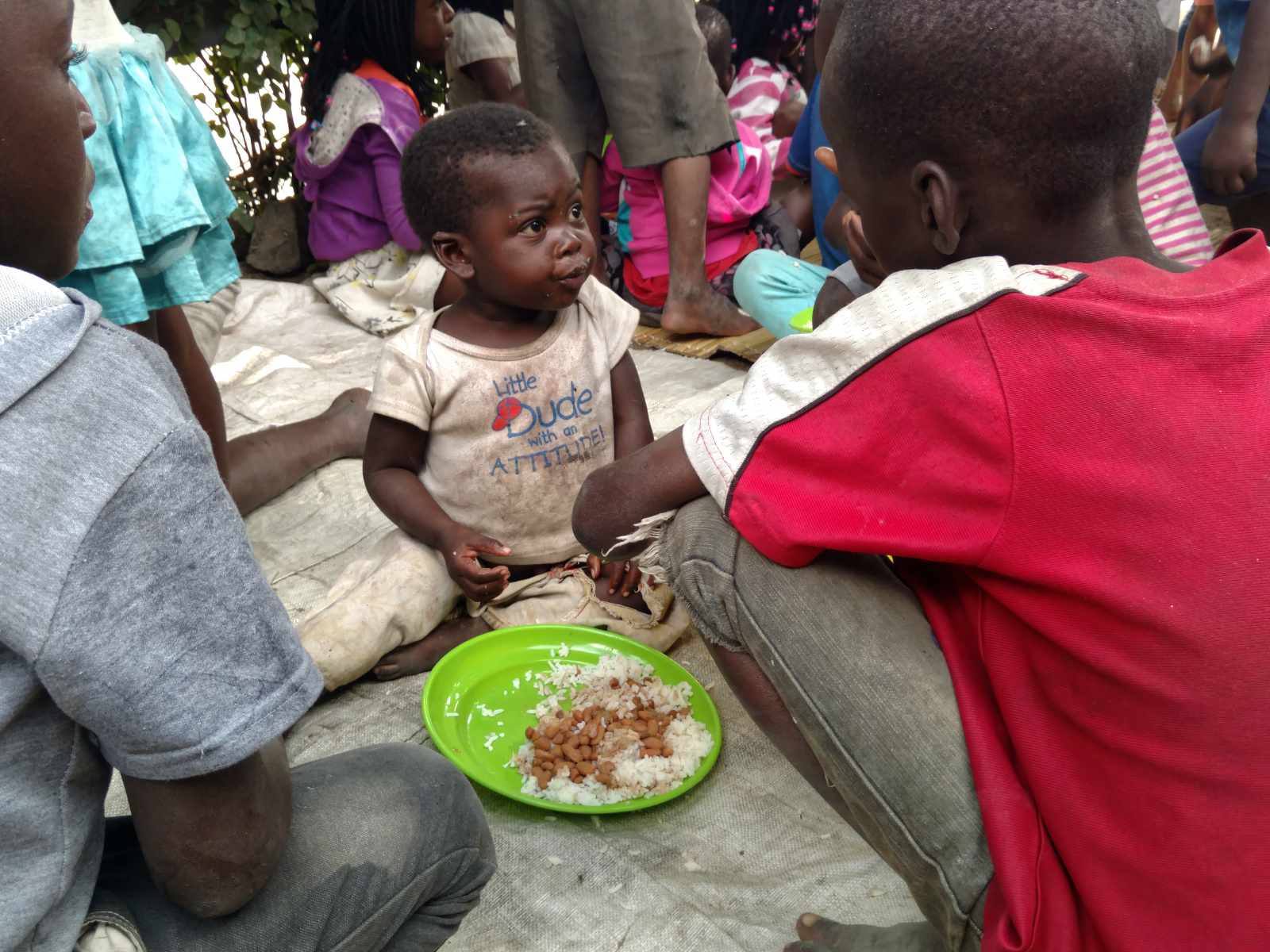 Children sharing plates of rice and beans together at a weekly children's gathering in Mozambique.