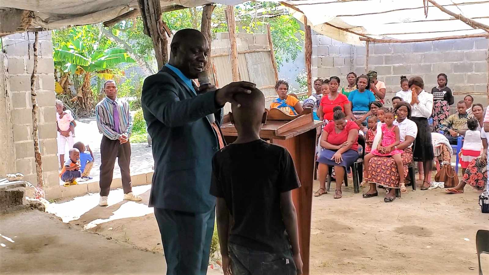 Pastor Abel praising a young boy in his church who showed up for an all night prayer event.